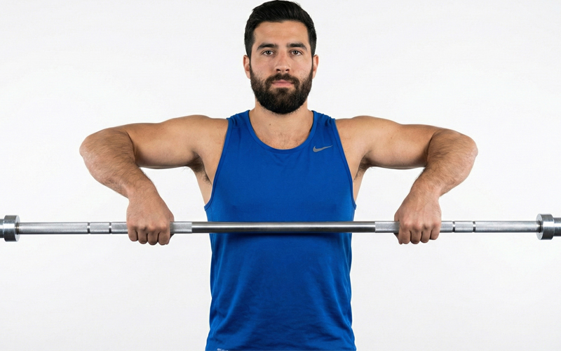 homem fazendo remada em pé com barra olímpica