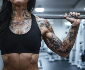 mulher fazendo musculação após fazer uma tatuagem