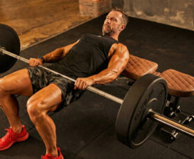 homem fazendo elevação de quadril com barra no treino de glúteo