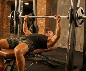 homem fazendo o exercício supino reto no smith