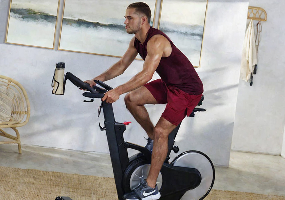 homem fazendo cardio em casa em uma bicicleta ergométrica
