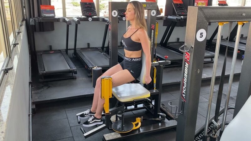 mulher fazendo o exercício cadeira abdutora 45 graus
