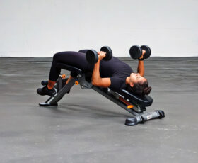 mulher fazendo supino declinado com halteres