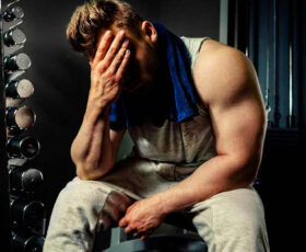 homem musculoso cansado na academia