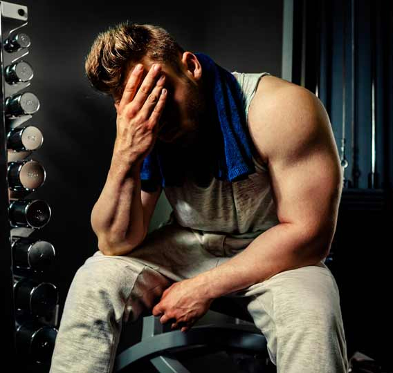 homem musculoso cansado na academia